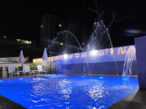 two water fountains in a pool at night at Apartamentos Villa Leonor in Coveñas