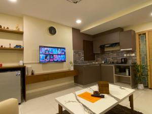 伊斯兰堡The Skyluxe Designer Suite with Rooftop Pool的厨房以及带墙上电视的客厅。