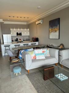 a living room with a couch and a kitchen at Deck 17 in Cozumel
