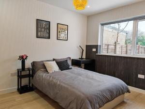 a bedroom with a large bed and a window at 2 Bedroom Cotswold Bungalow in Castle Combe