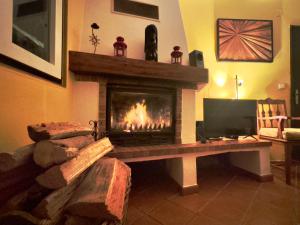 Una sala de estar con chimenea y televisión. en Casa do Candeeiro, en Óbidos