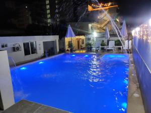 a large swimming pool at night with blue illumination at Apartamentos Villa Leonor in Coveñas