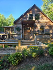 a log cabin with a porch and a front door at Couples Getaway Cabin with a Loft Bed - Firepit - Creek Access in Dahlonega
