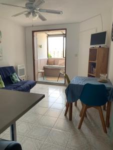 a living room with a couch and a table at escapade vue sur le port in Leucate-Plage
