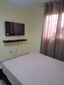 a bedroom with a bed and a tv on a wall at Encantador Apartamento Pequeño in Hornillo