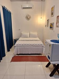 a small bedroom with a bed and a tv at Buddha Suítes in Pipa