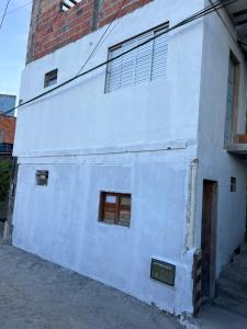 un edificio bianco con due finestre e una porta di Loft na praia com vista a Itaparica
