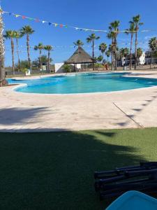a large swimming pool with palm trees and a beach at Departamento en Nuevo Altata in Isla de Redo