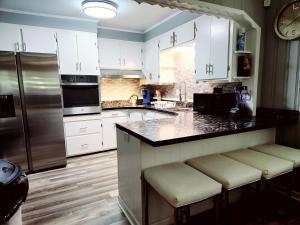 a kitchen with white cabinets and stainless steel appliances at Chickasaw Landing in Chickasaw