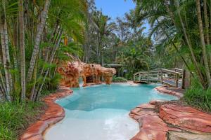 a pool in the middle of a resort with a giraffe at Luxury Beach Studio - Aanuka Beach Resort in Coffs Harbour