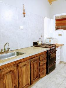 a kitchen with a sink and a stove at Casita del Centro in San Clemente del Tuyú