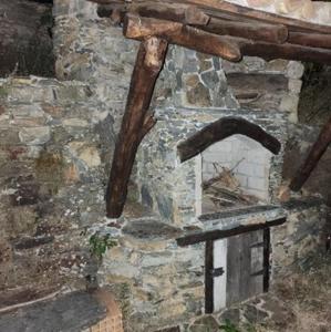 um forno de pedra com uma parede de pedra em Casa da Pedra em Talasnal