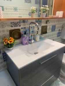 a sink in a bathroom with flowers on it at Anthony House in Villafranca Tirrena +39 photos