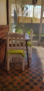 a wooden bench sitting next to a table at Casita del Centro in San Clemente del Tuyú