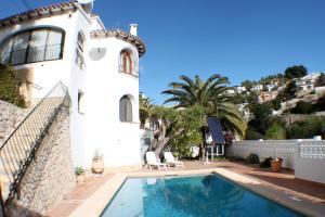 a villa with a swimming pool in front of a house at Luz - holiday apartment in peaceful surroundings in Benissa in Benissa