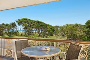 a table and chairs on a balcony with a view of the ocean at Pacific Palms 4 Unit 4, 9-11 Terrace St Evans Head in Evans Head