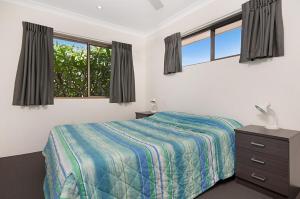 a bedroom with a bed and a dresser and windows at Pacific Palms 4 Unit 4, 9-11 Terrace St Evans Head in Evans Head