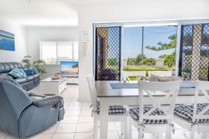 a living room with a table and chairs and a couch at Sunrise on Terrace Unit 3, 21 Terrace Street Evans Head in Evans Head