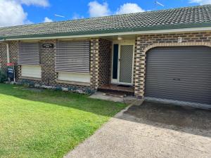 a brick house with two garage doors on it at Whispering Pines Unit 3, 7 Waratah Lane Evans Head in Evans Head