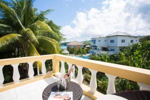 a table on a balcony with a view of the ocean at Villa Serenity Jamaica in Tower Isle