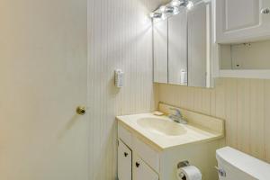 a white bathroom with a sink and a mirror at Walk to Parks and Dining Quaint Alexandria Condo! in Alexandria +17 photos