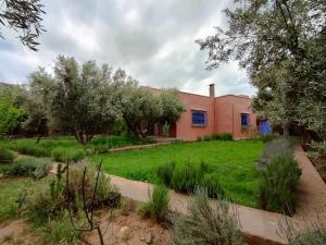 a house with a yard with grass and trees at Tissi House in Tahannout