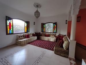 a living room with a couch and stained glass windows at Tissi House in Tahannout