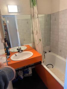 een badkamer met een wastafel en een ligbad bij La montagne in Villarembert