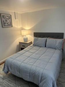 a bedroom with a bed and a night stand with a lamp at Escape to Atlantic City in Atlantic City