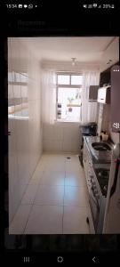 a small kitchen with a stove and a window at Apartamento Canto do Forte in Praia Grande