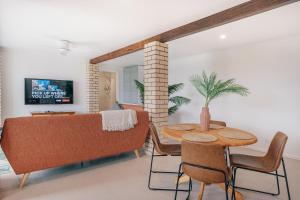 una sala de estar con una mesa y un sofá en Wave Cave Suite, en Coffs Harbour