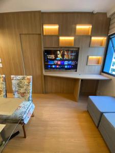 a room with a tv and a couch and a chair at Ninety Stay Premium in Sao Paulo