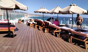 a wooden deck with chairs and umbrellas on a roof at Cabo bay in Cabo San Lucas +2 photos
