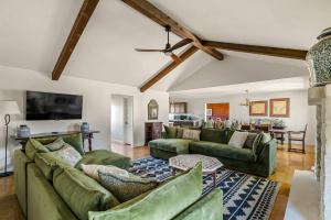 a living room with green couches and a table at Relaxing Hill Country Home with Outdoor Fire Pit in Waring