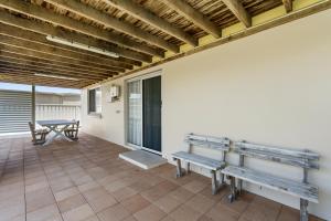 a patio with benches and a table and a table at Shades Of Summer 50 Park Street in Evans Head