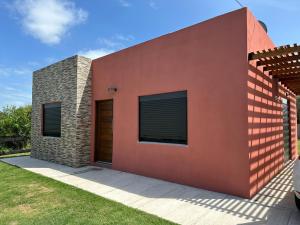 a modern house with a red wall at ᗷᖇᑌᗰᗩ in Barra del Chuy