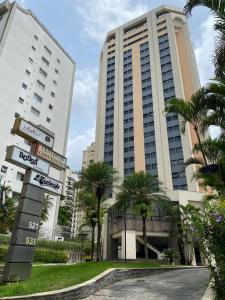 a large building with palm trees in front of it at Ninety Stay Premium in Sao Paulo