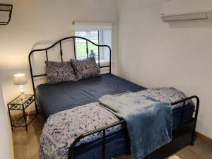 una piccola camera da letto con un letto e una finestra di Chalet des sources. a Wasseiges