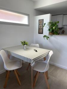 een eettafel met witte stoelen en een gestreepte tafel bij Rosario SJ Loft in Rosario