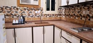 a kitchen with a sink and a counter top at خيال الفارس للشقق المخدومة in Quwayzah