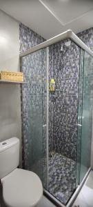 a bathroom with a glass shower with a toilet at Casa Seridó - Caicó in Caicó