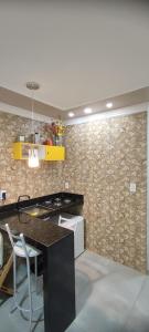 a kitchen with a black counter and a chair at Casa Seridó - Caicó in Caicó