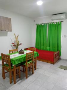 a living room with a table and a green curtain at Miró departamento con cochera in Villa María