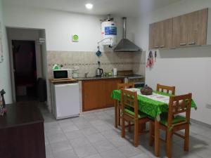 a kitchen with a table and chairs and a kitchen with a microwave at Miró departamento con cochera in Villa María +5 photos