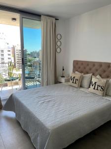 een slaapkamer met een groot bed en een balkon bij Rosario SJ Loft in Rosario