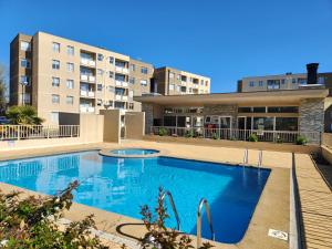 a swimming pool in front of a building at Departamento equipado Parque Oriente in Temuco