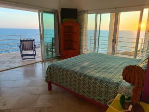 una camera da letto con un letto e vista sull'oceano di Hotel Luz de Mar ' right on the beach a Cuatunalco