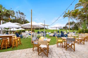 a group of tables and chairs with umbrellas at Elvis - The Great Seaside Escape - Luxury Stay in Coffs Harbour