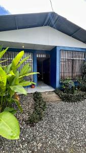 a blue and white building with a door at Blue House with Pool and Air-Conditioning in Puerto Jiménez