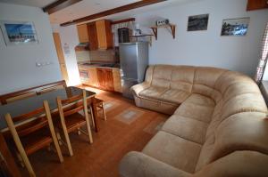 sala de estar con sofá, mesa y cocina en Holiday Home Cokla, en Zreče